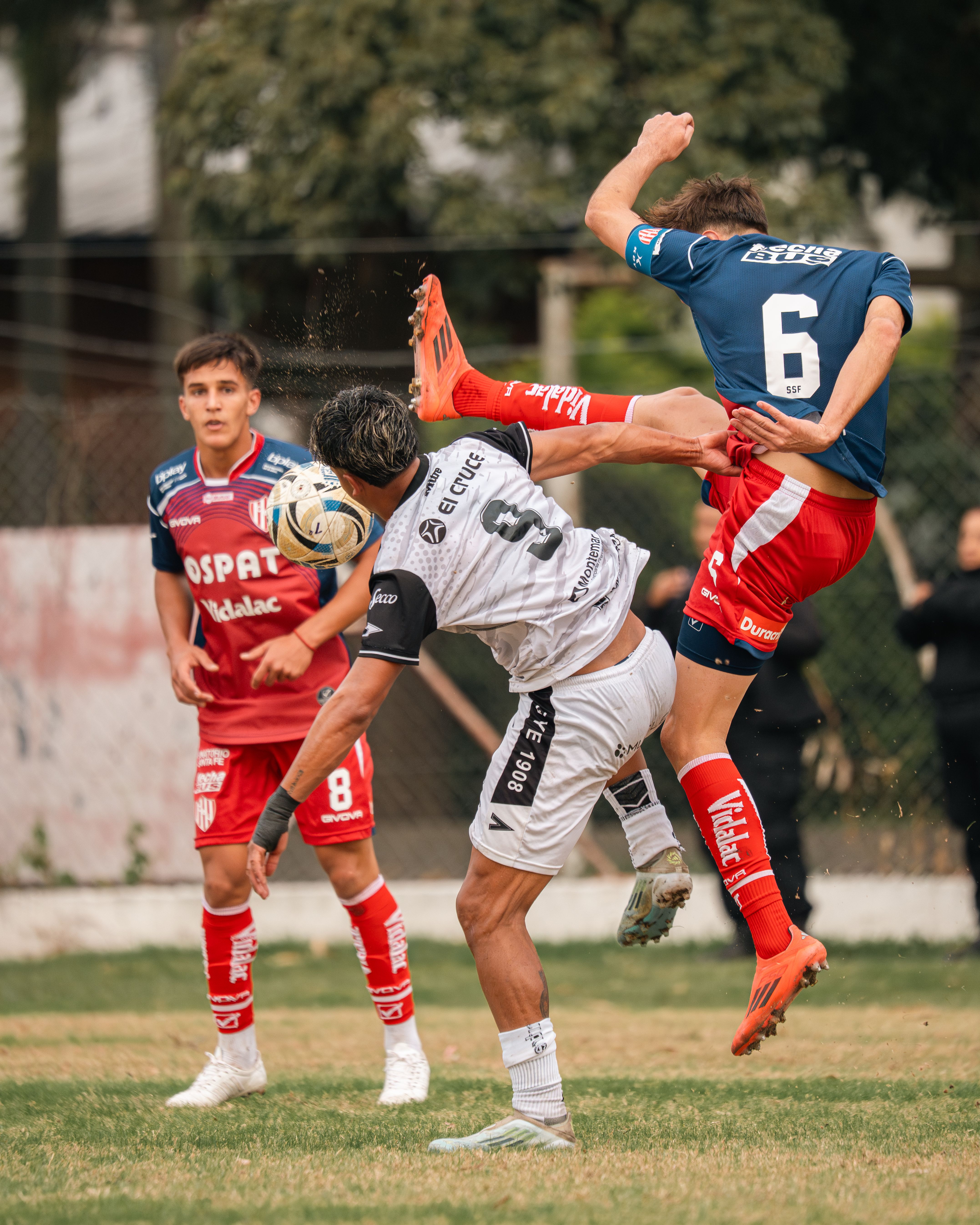 Soccer players in intense action on the field during a dynamic match.