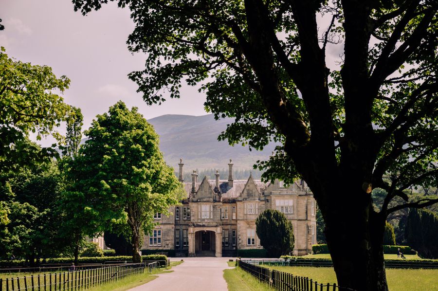 View of Muckross House in Killarney, surrounded by greenery and mountains