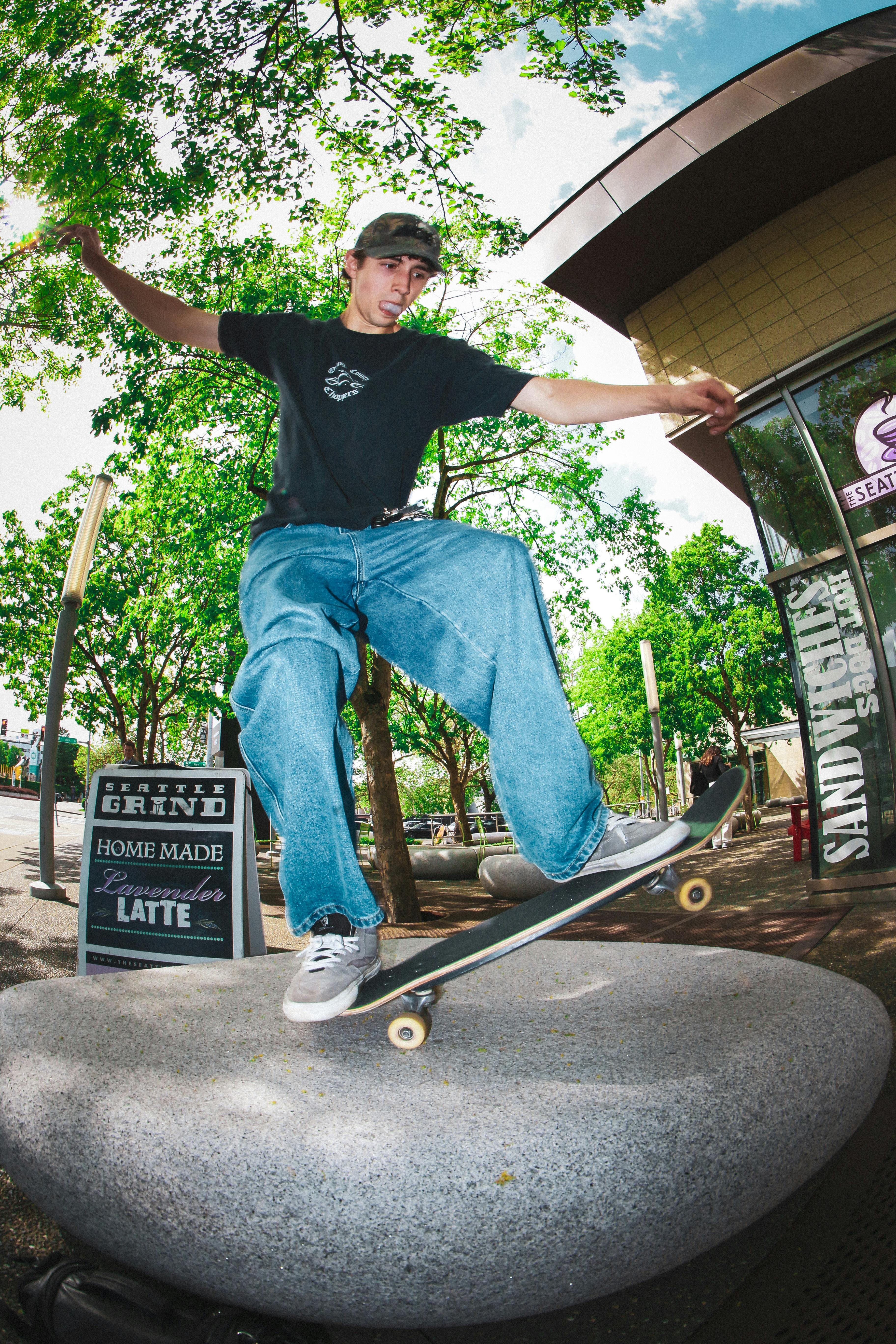 A young skateboarder performing an ollie on a city street, showcasing urban skate culture.
