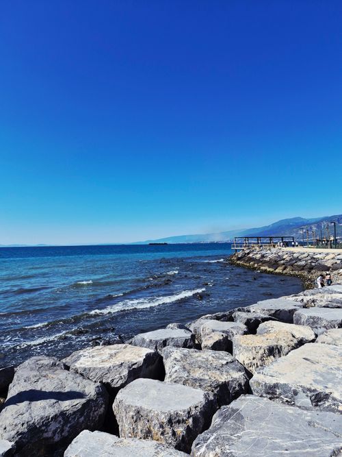 Free Experience the serene beauty of a rocky coastline with clear blue waters. Stock Photo