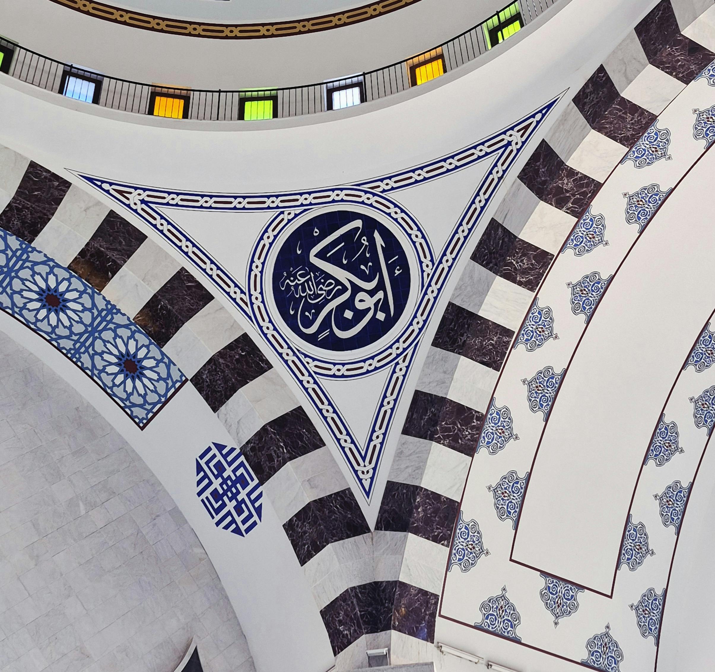 A stunning detail of Islamic architectural artwork featuring intricate geometric patterns and Arabic calligraphy.