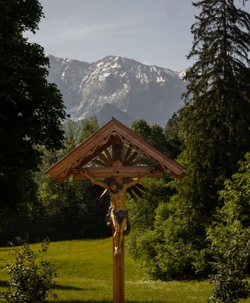Free A wooden cross standing in a lush field with snowy mountains in the background, Panningen, Netherlands. Stock Photo