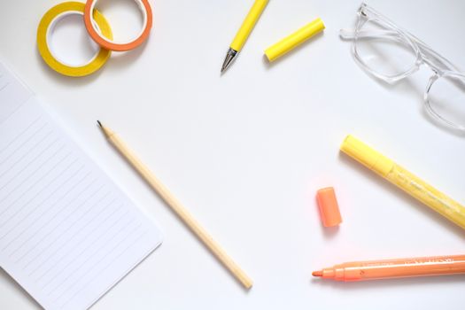 Flat lay of stationery items on a desk with a minimalist aesthetic and bright colors.