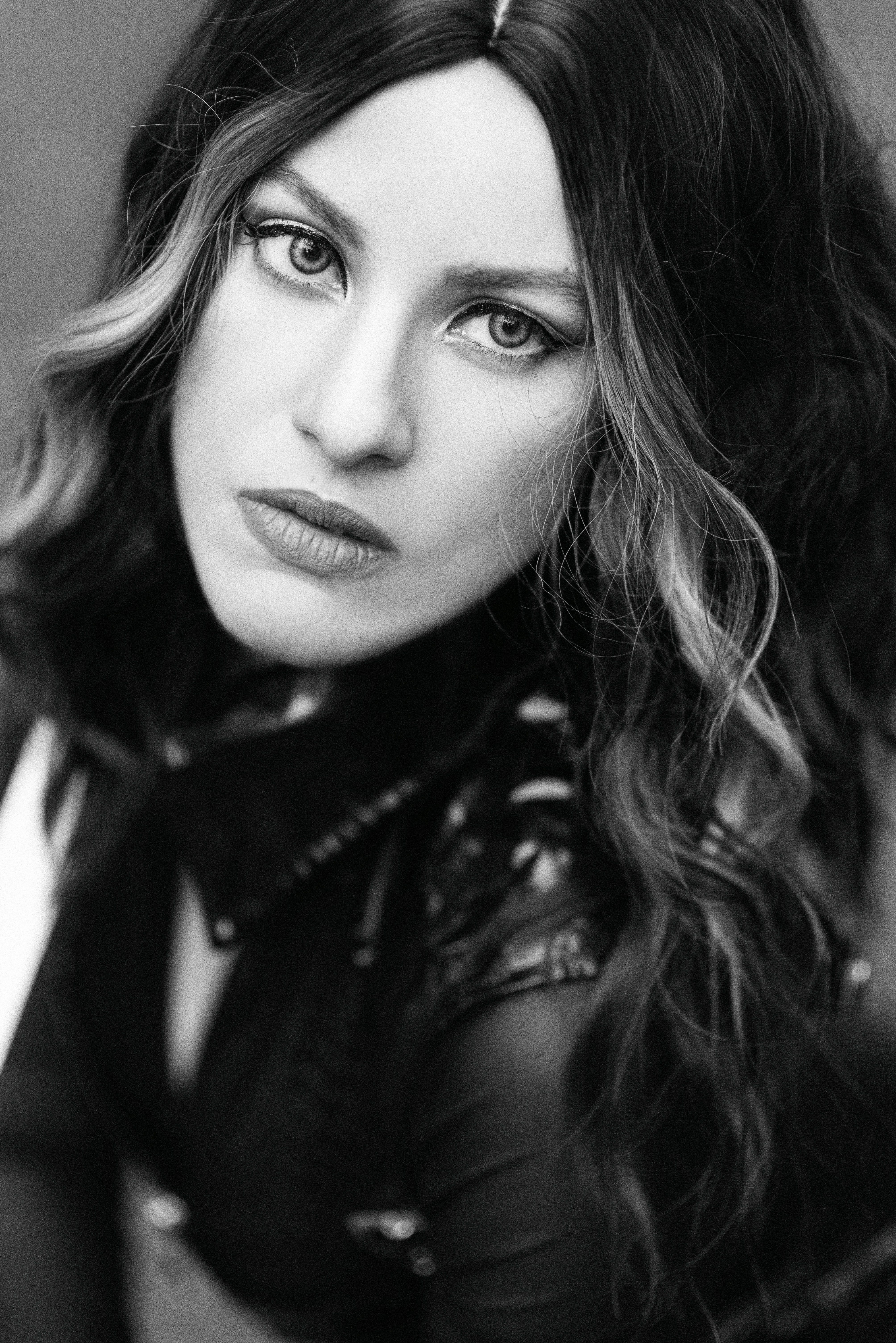 Striking black and white portrait of a confident woman in leather attire promoting empowerment.