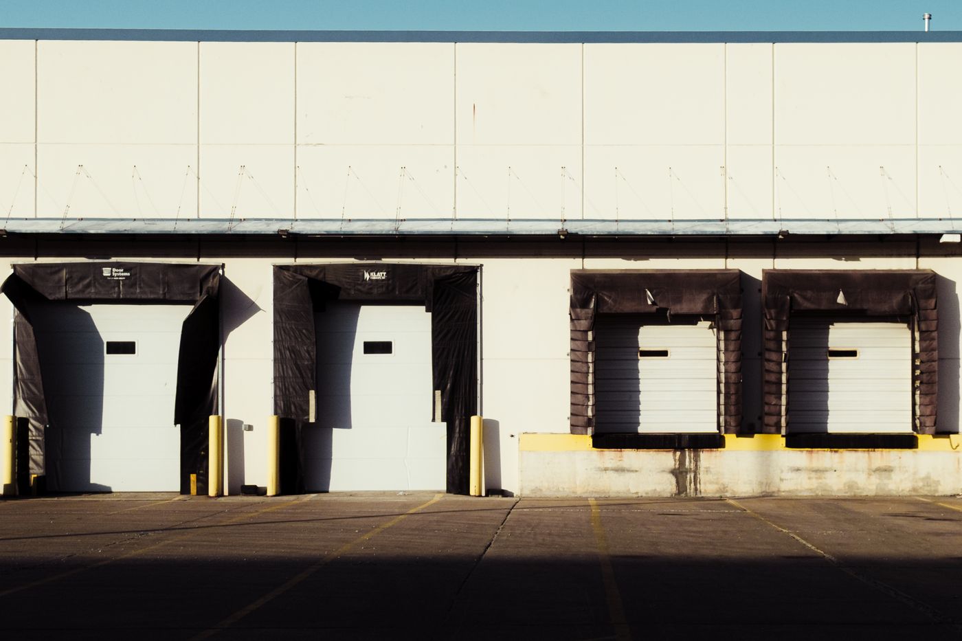 Industrial loading bays and closed dock doors in sunlight