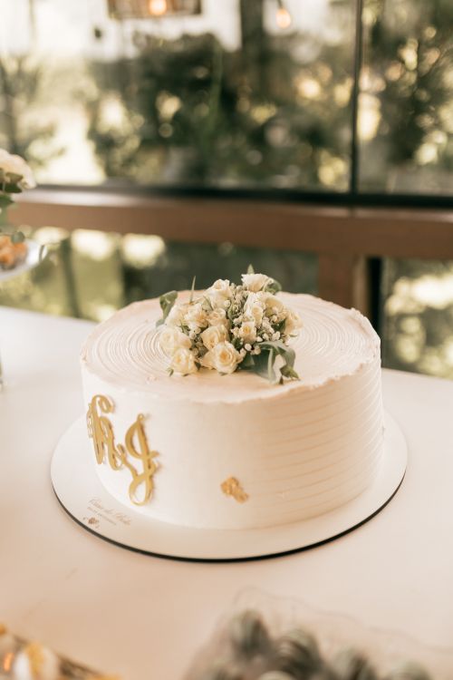Free A beautifully decorated wedding cake adorned with white roses and gold initials, perfect for celebrations. Stock Photo