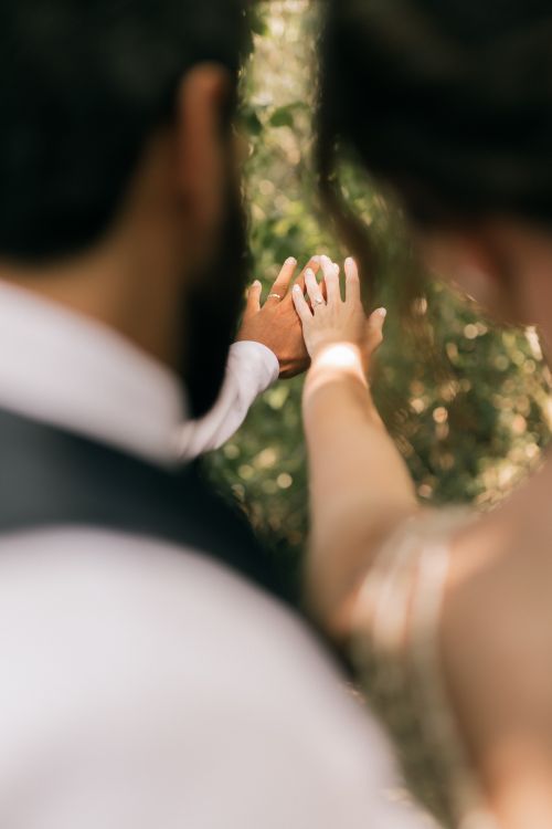 Free Romantic close-up photo of a couple holding hands in an outdoor setting. Stock Photo