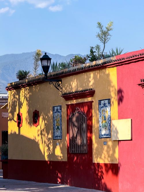 Free Vibrant street scene in Oaxaca featuring colorful buildings and mountain backdrop. Stock Photo