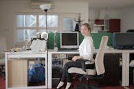 Elegant female employee sitting on chair in modern workplace