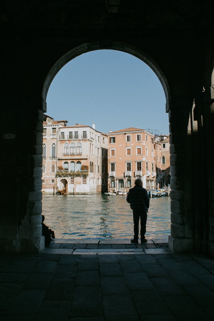 A Man Standing Beside Body Of Water