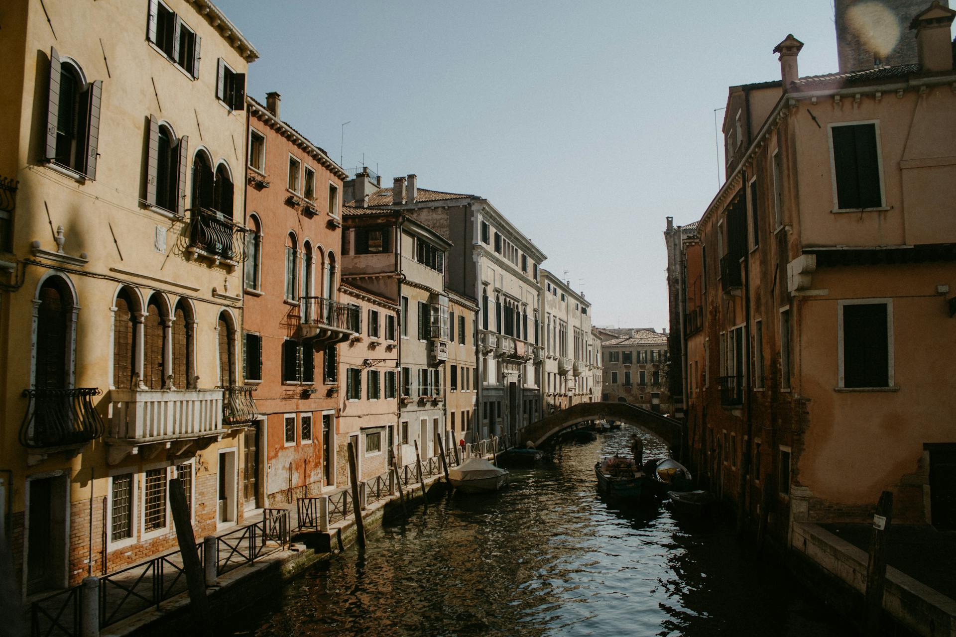 Charming view of a Venetian canal with historic buildings lining the waterway on a sunny day.