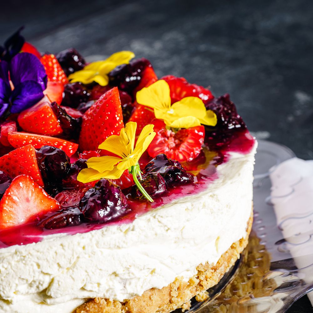 Torta decorata con frutti di bosco e fiori eduli