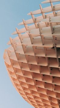 Close-up of the Metropol Parasol in Seville, highlighting architectural details against a blue sky.