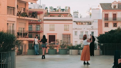 Free A group enjoying an evening on a rooftop terrace in Seville, highlighting urban life and architecture. Stock Photo