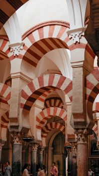 Red and white Moorish arches inside the historic Mosque-Cathedral of Córdoba, Andalusia, Spain.