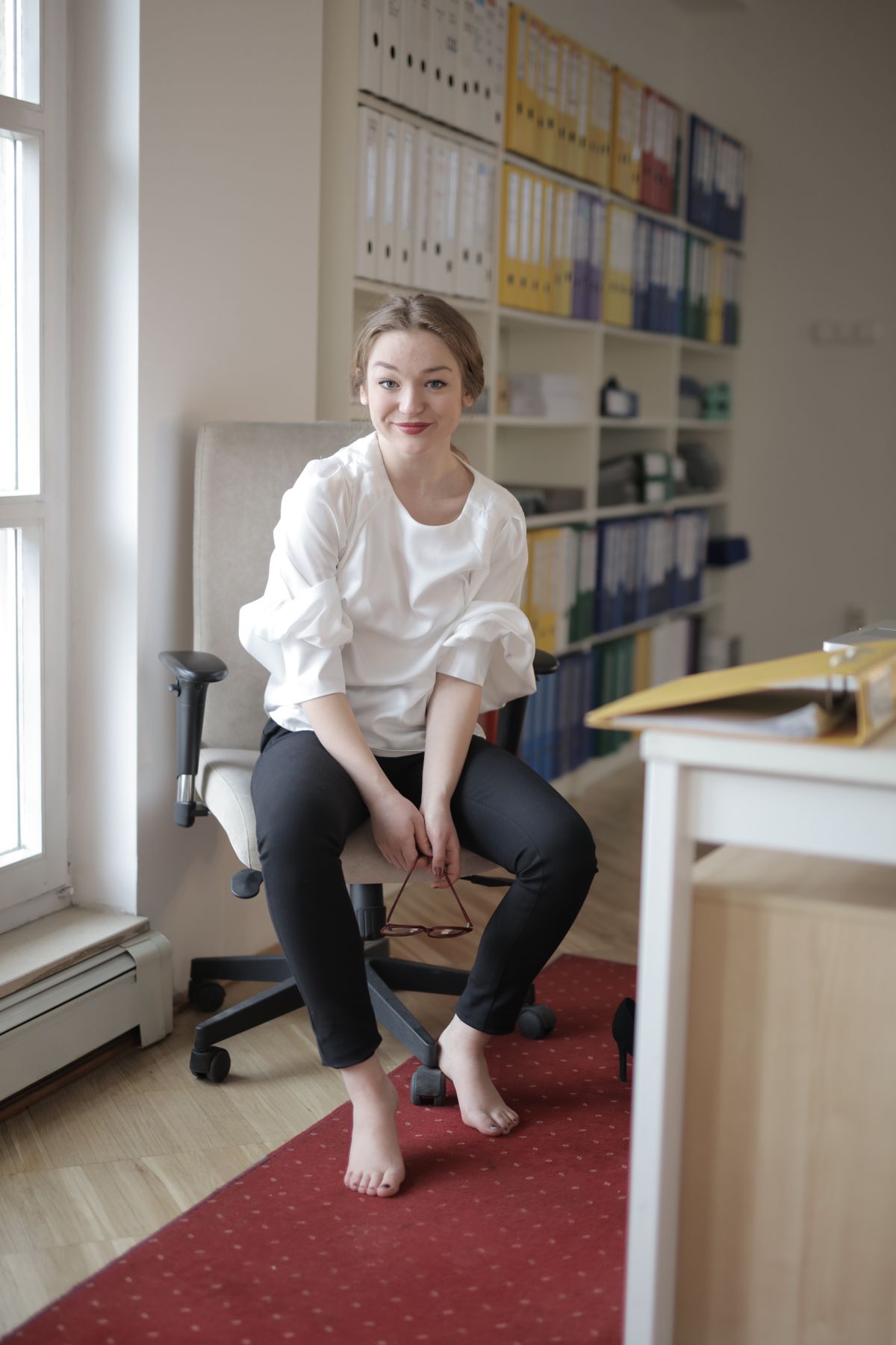 A woman wearing a white poplin shirt with high-rise tapered trousers