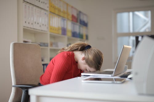 Donna Che Si Siede Sulla Sedia Mentre Si Appoggia Sul Computer Portatile