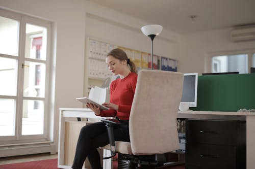 Woman Seated on a White Office Chair 