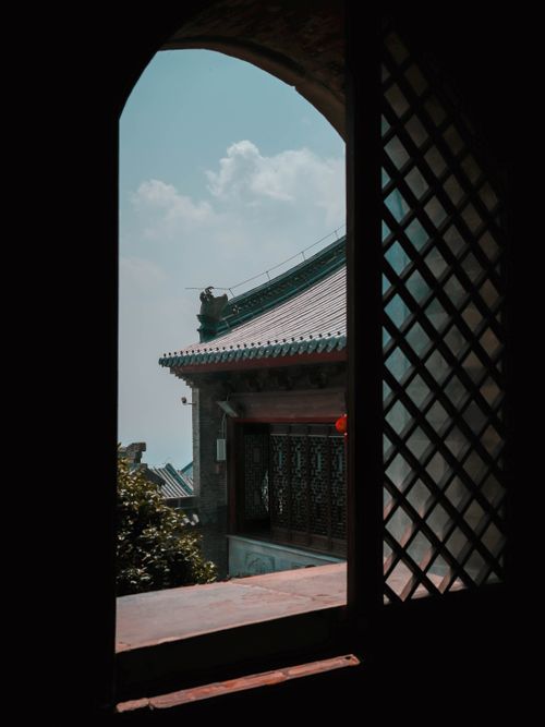 Free View of Asian architectural details through an arched window under a clear sky. Stock Photo