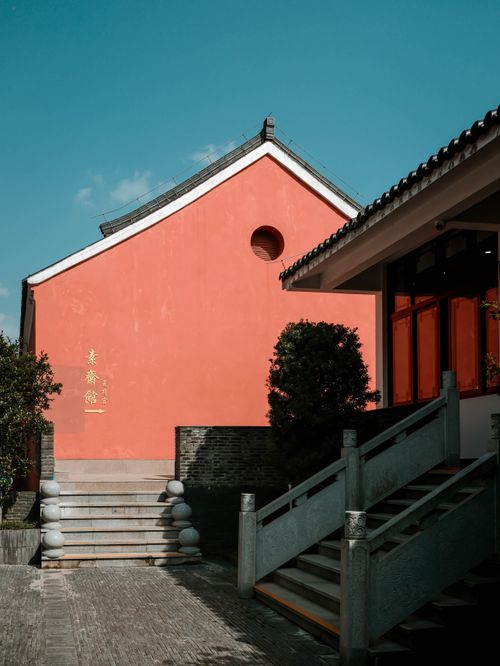 Free A traditional building with a vibrant red facade under a clear blue sky. Stock Photo
