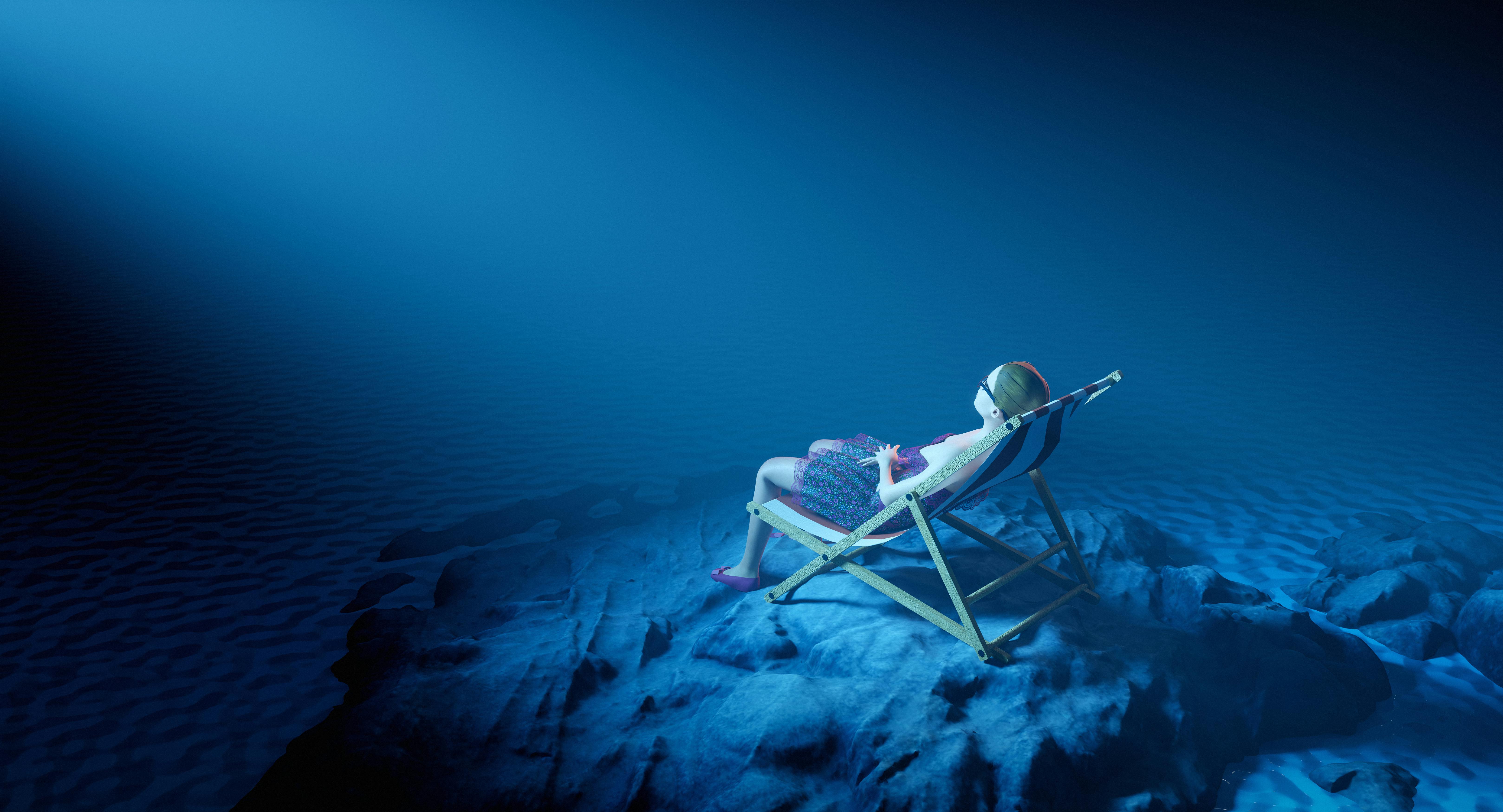 A surreal scene of a woman lounging underwater in a chair amidst serene blue tones.