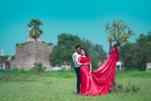Free Couple embracing in a vibrant red dress with Golconda Fort in the background. Stock Photo