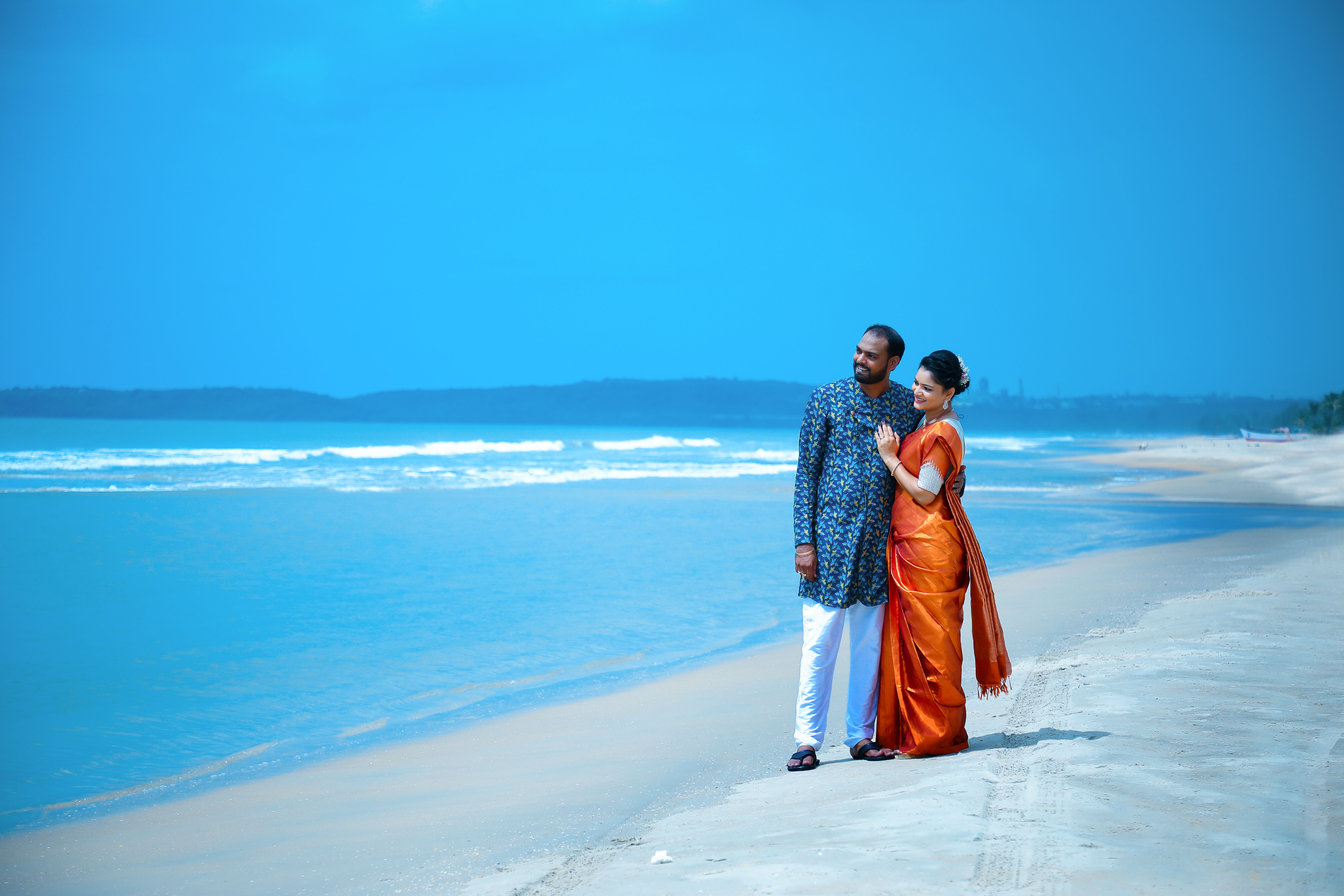 A couple in traditional attire enjoying a serene moment on a Hyderabad beach.