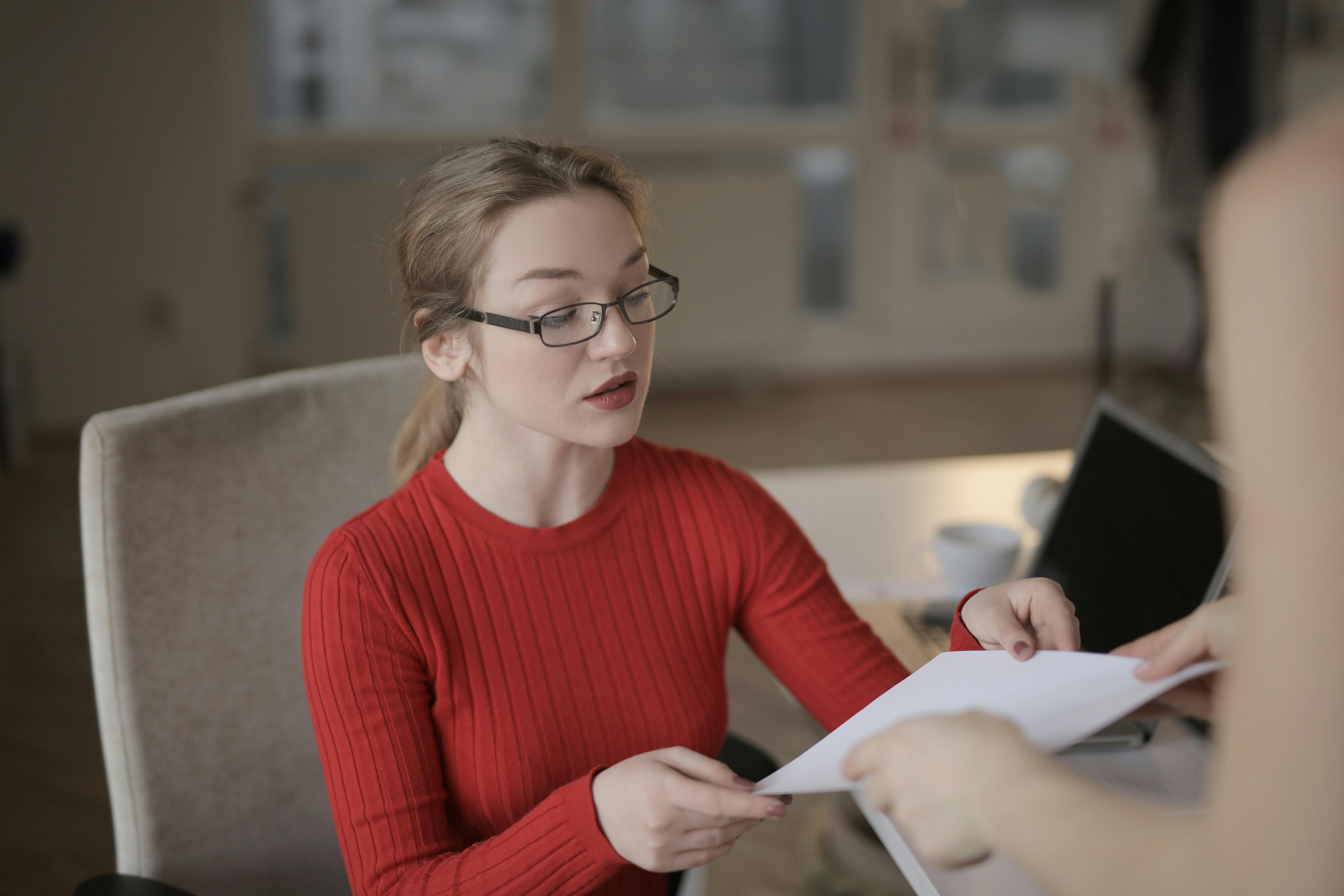 Office Environment With A Person Looking Confused While Receiving Last-minute Updates From A Colleague, Showing A Lack Of Communication And Information Sharing