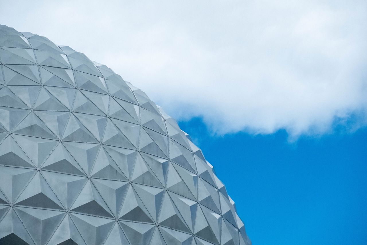 a striking geodesic dome structure set against a vibrant blue sky with