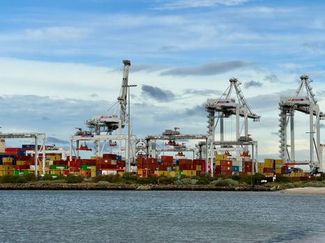 Colorful shipping containers and cranes at a bustling port in Victoria, Australia.
