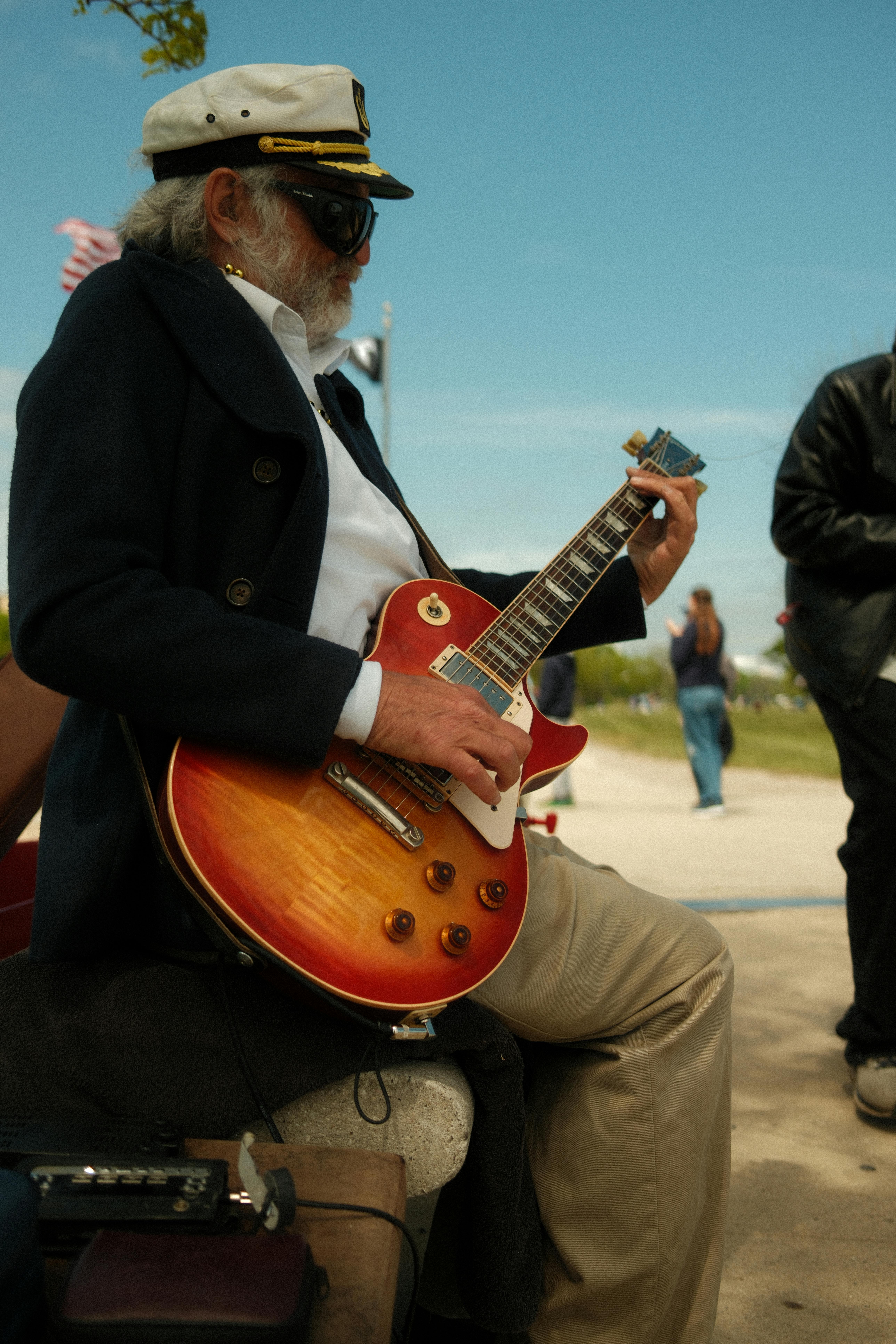 Captivating shot of a senior man playing guitar outdoors, exuding charm and passion.