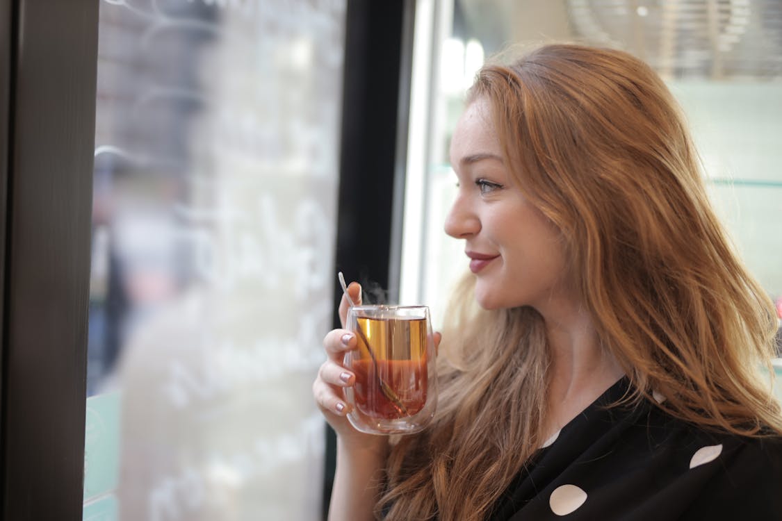 Satisfied woman enjoying tea in cafe