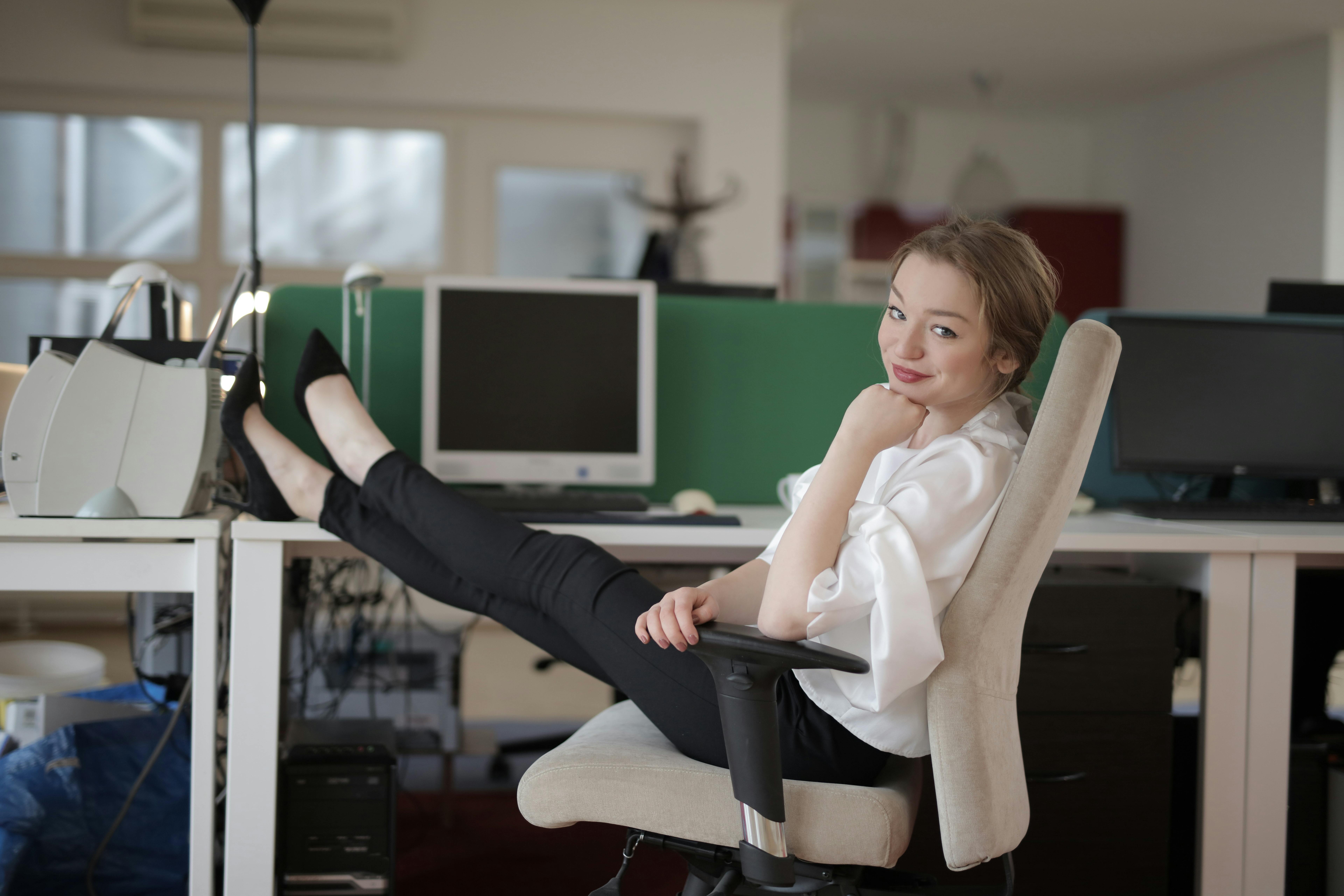 smiling elegant female employee with feet on table