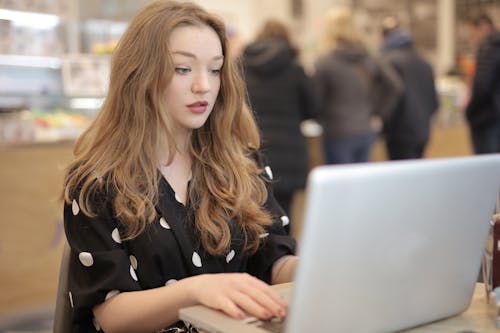Wanita Berkemeja Polka Dot Hitam Putih Menggunakan Komputer Laptop Perak