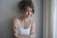 一位卷发微笑的女人在室内自然光下摆着姿势