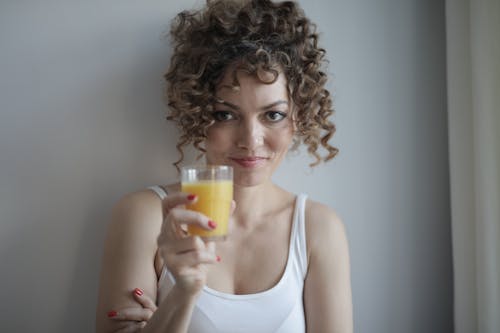 Woman in White Tank Top Holding Clear Drinking Glass