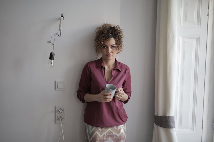 Lonely Woman With Cup Of Coffee At Home