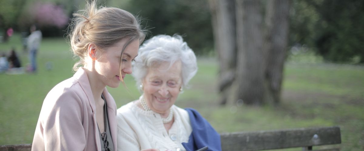 Family member helping elderly parent with technology