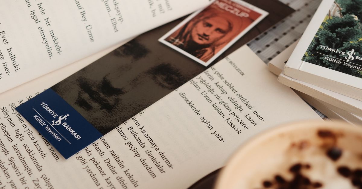Open book with bookmark and coffee on a table, creating a cozy reading atmosphere.
