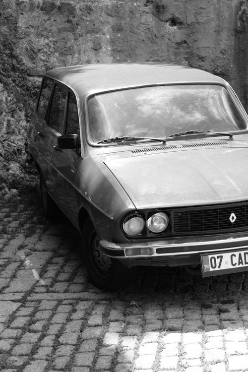 Free Vintage Renault car parked on a cobblestone road, captured in black and white. Stock Photo