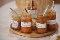 A selection of Hungarian vegetable spreads in jars on a wooden tray.