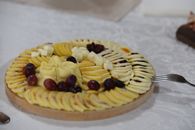 A beautifully arranged cheese platter with grapes and rustic decor, perfect for events.