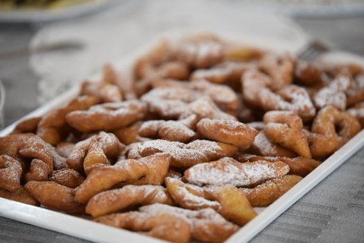 A tray of traditional Hungarian pastries dusted with powdered sugar, perfect for dessert lovers.