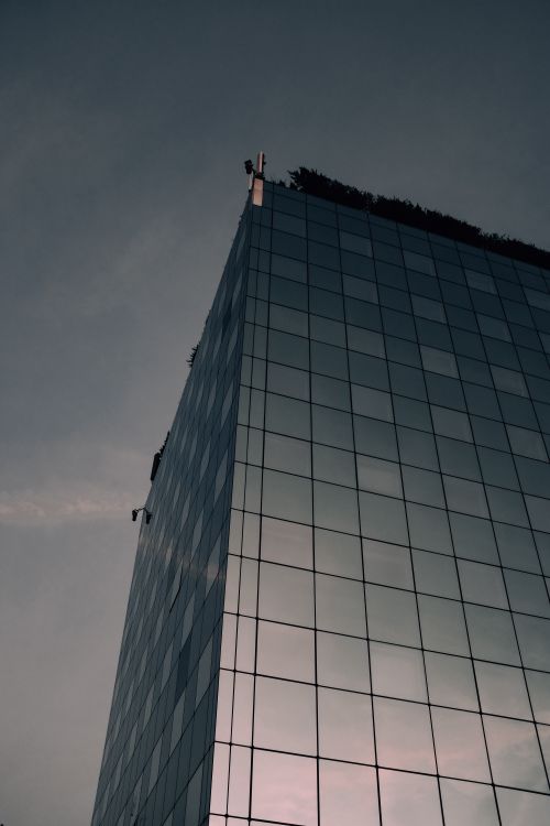 Free Skyscraper with glass facade reflecting the evening sky, showcasing modern urban architecture. Stock Photo