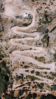 A breathtaking aerial shot of a winding zigzag road in the rocky terrains of İzmir, Türkiye.