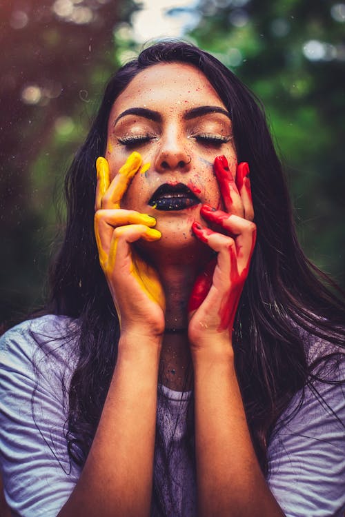 Free Woman in Gray Crew Neck Shirt With Yellow and Red Paint on Her Hand Stock Photo