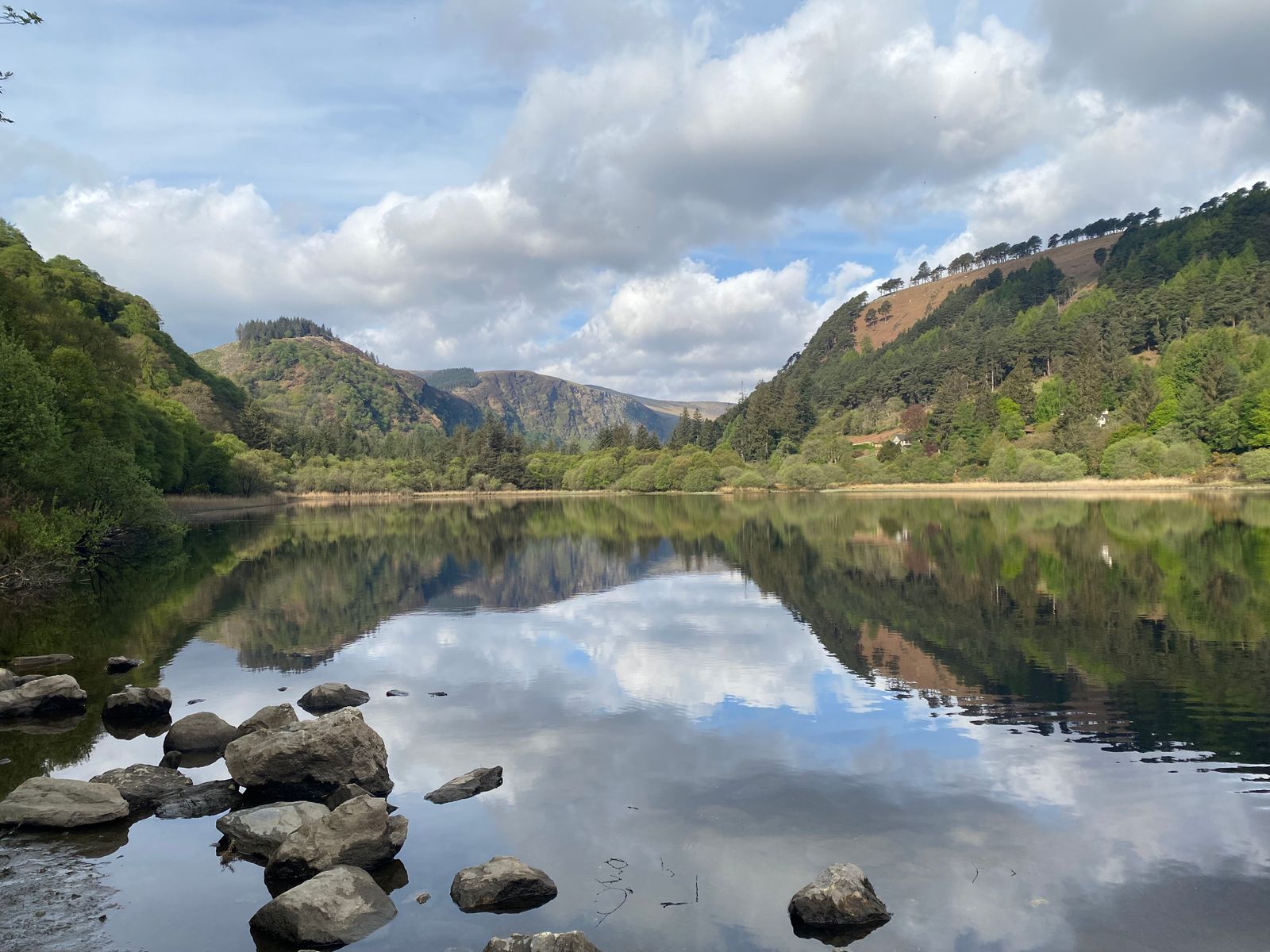 View of Upper Lake in Glendalough with reflections of mountains and trees