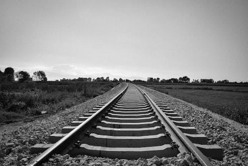 Grayscale Photo of Train Rail