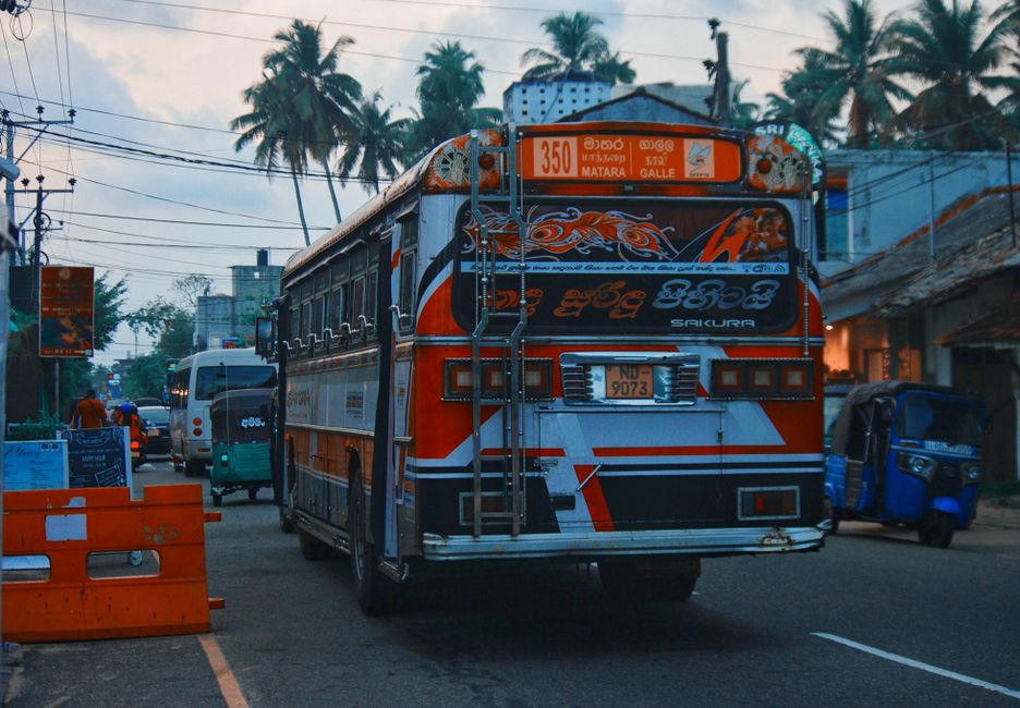 A vividly decorated bus on a busy Sri Lankan street at dusk A vividly decorated bus on a busy Sri Lankan street at dusk