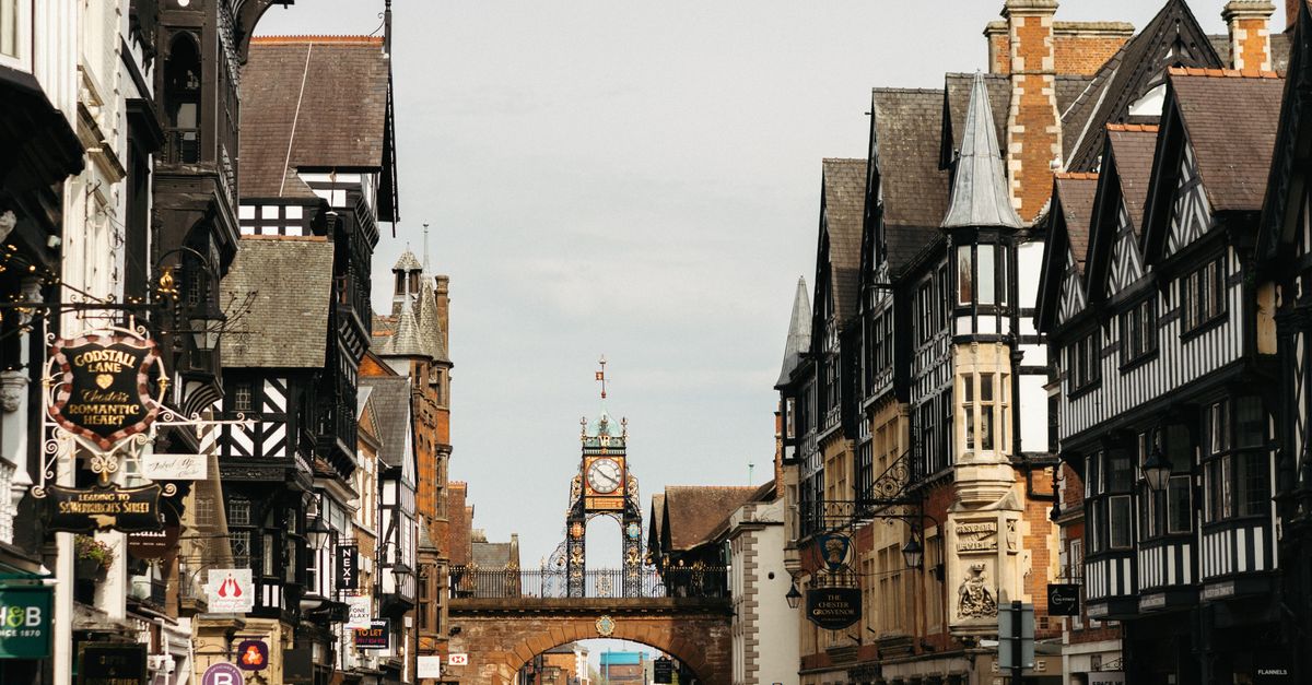 Busy street in Chester, England, featuring medieval architecture and the iconic Eastgate Clock.